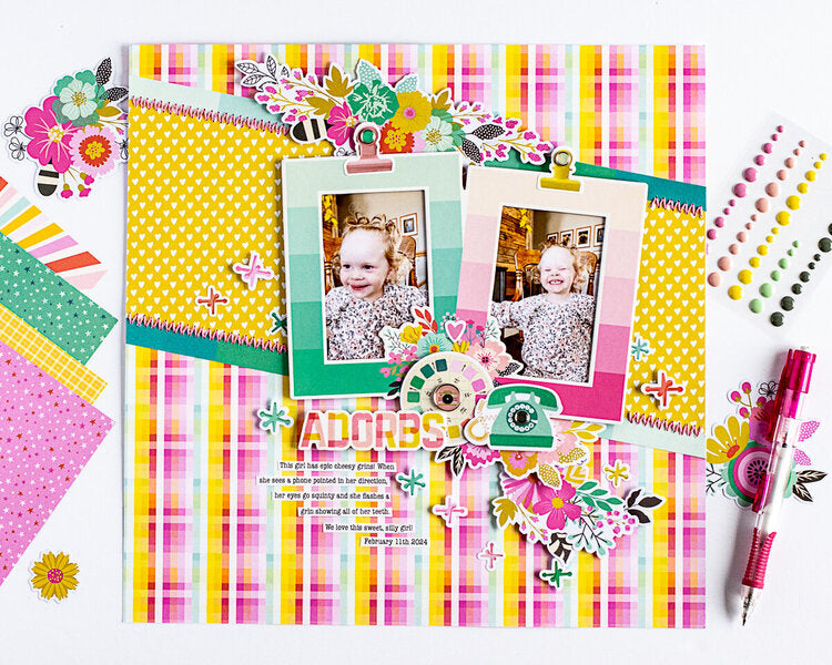 Colorful scrapbook page with photos, decorative elements, and a pen on a white background.