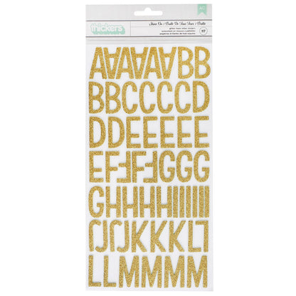 Packaging of gold glittery letter stickers on a white background